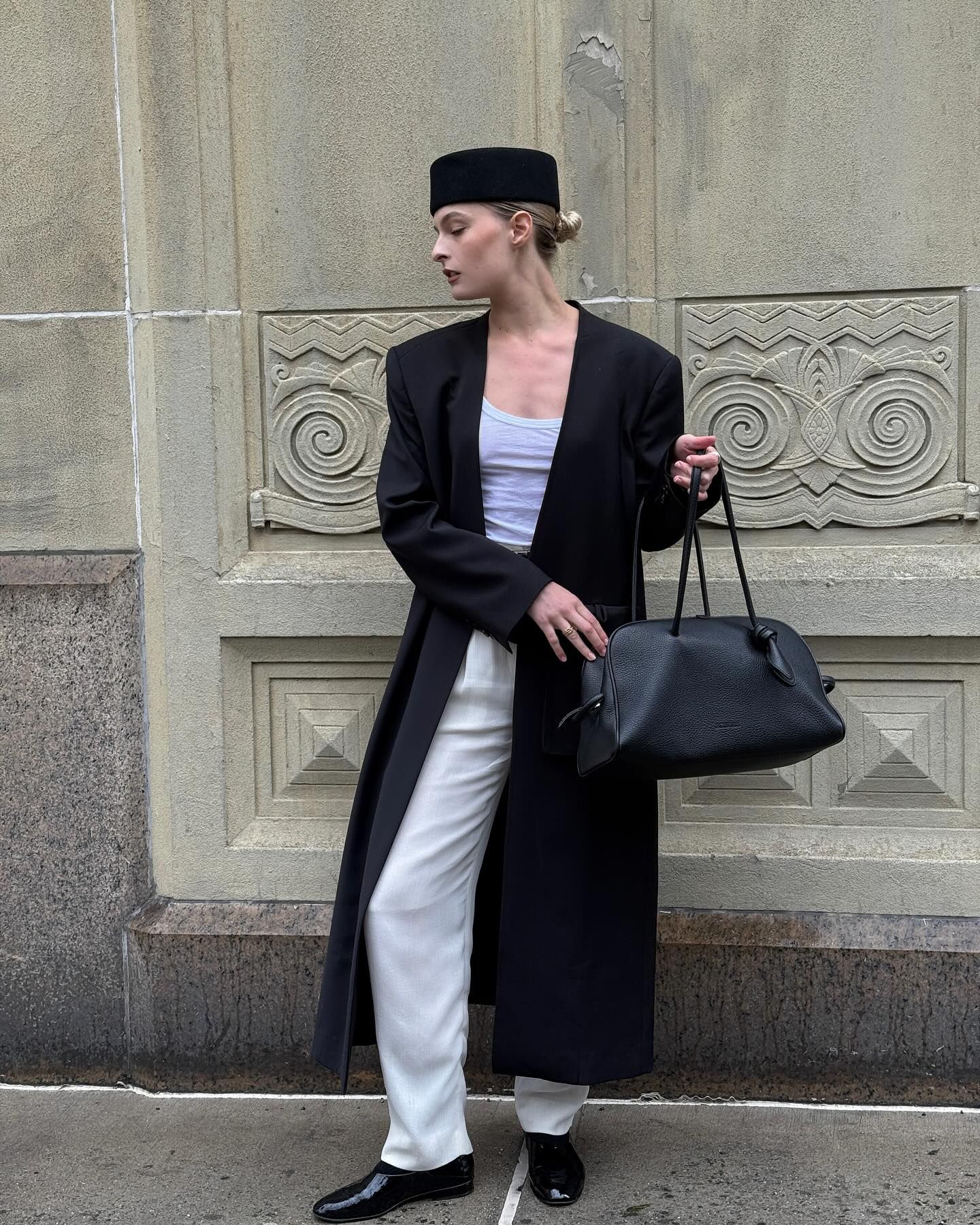 Woman on street in black coat, bag and hat