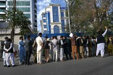 Afghans line up at an ATM machine.