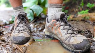 徒步旅行者在水坑里穿登山鞋