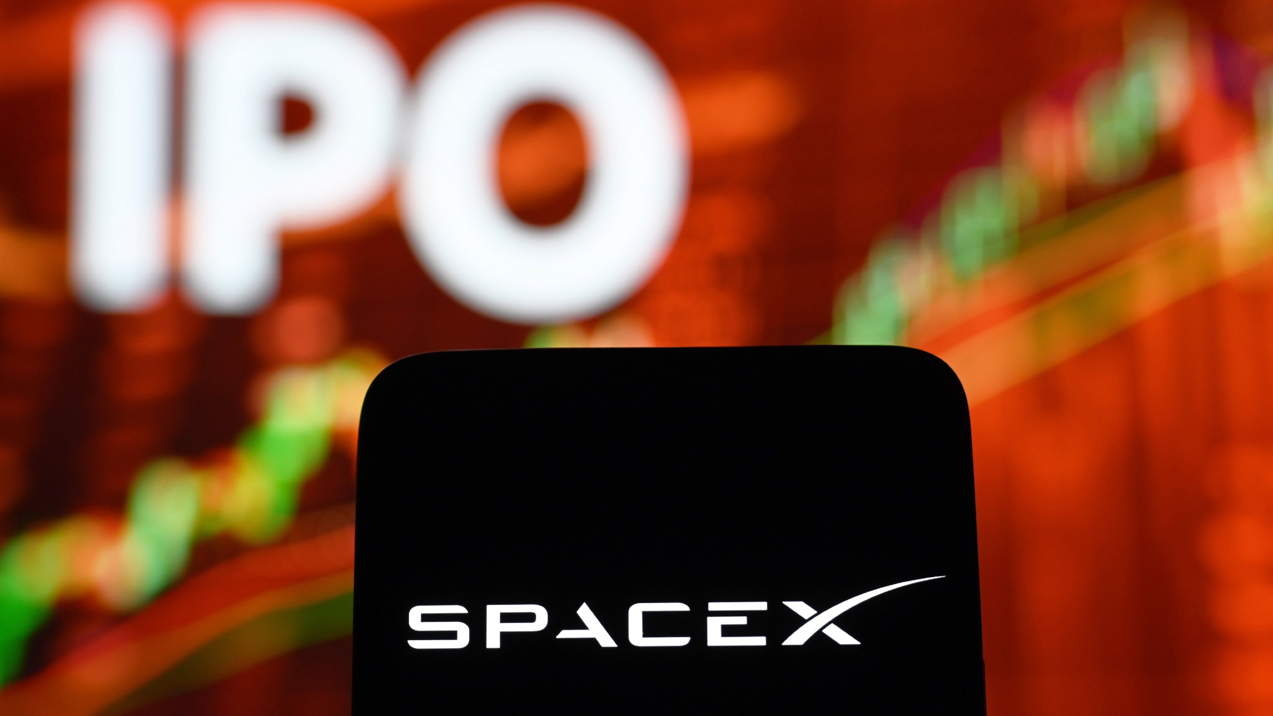  Spacex logo on a mobiel phone with an IPO stock illustration in background