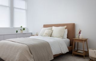 A clean and tidy bedroom with white and cream textured bedsheets