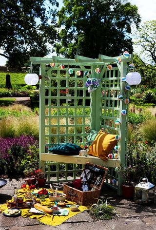 mini arbor with bench and trellis painted in green