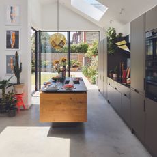 Black kitchen with wooden island and dark worktops