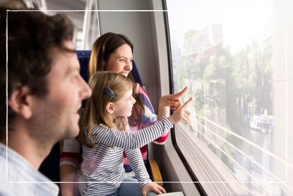 parents and child looking and pointing out of the window on a moving train