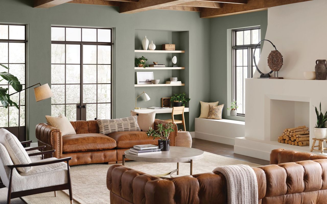 Living room with green feature wall, leather sofa and wooden beams