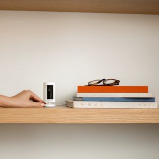 ring camera with books and wooden shelves