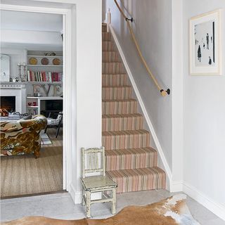 white hallway with staircase and carpet