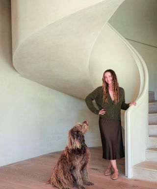 woman and dog by plaster spiral staircase
