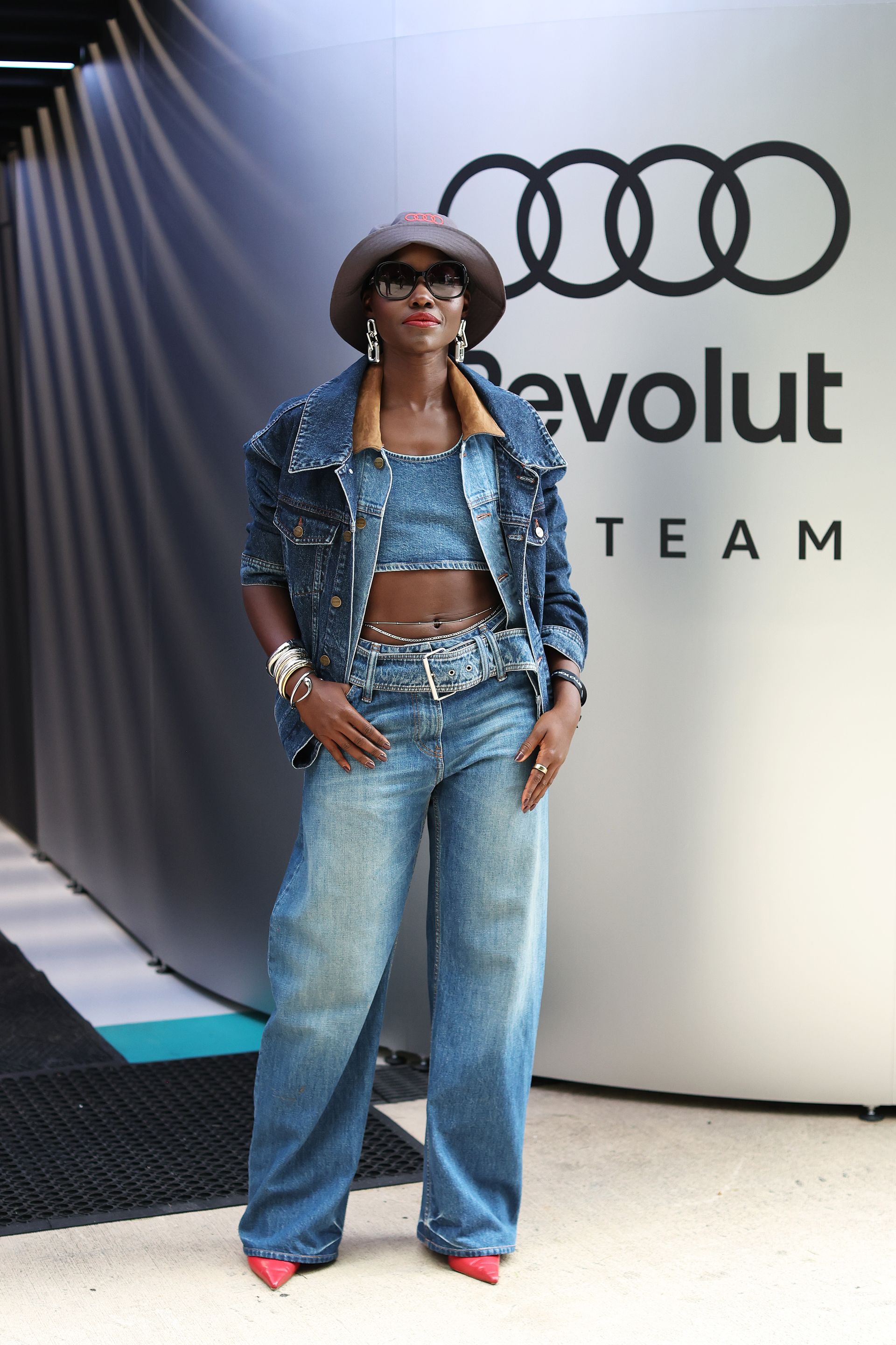 MIAMI, FLORIDA - MAY 03: Lupita Nyong'o poses for a photo in front of the Audi F1 Team garage prior to the F1 Grand Prix of Miami at Miami International Autodrome on May 03, 2026 in Miami, Florida. (Photo by John Phillips/LAT Images)