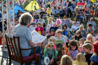Tall tales, Marks reads to children in the bandstand at Camp Bestival in 2014