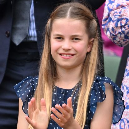 Princess Charlotte clapping and wearing a blue dotted dress