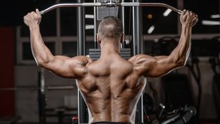 Man performing lat pulldown with wide grip on the bar in the gym