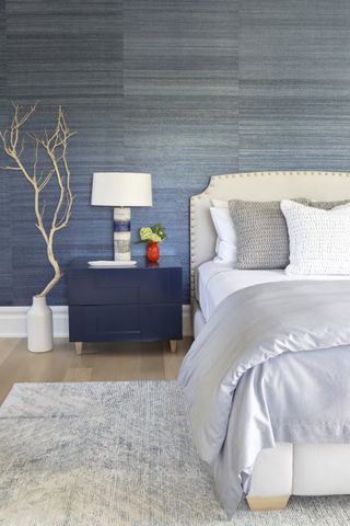 Bedroom with blue textured wallpaper and white tree branch