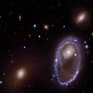 A composite image of the ring galaxy AM 0644-741. The image includes X-ray data from the Chandra X-ray Observatory (purple) and optical data from NASA's Hubble Space Telescope (red, green and blue). The galaxy AM 0644 is located in the lower right.