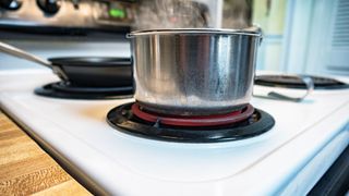 A pan of boiling water on an electric stove top burner