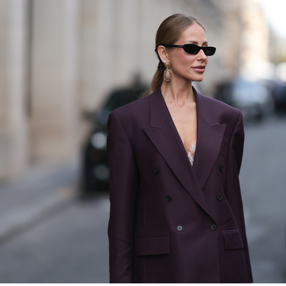 Alcohol-free perfumes Ginta is seen wearing a dark purple, double-breasted suit from Dries with strong shoulder pads at the Paris Fashion Week on October 02, 2025 in Paris, France.