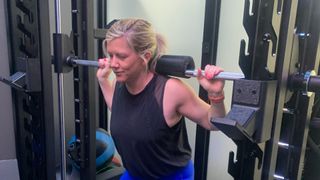 Sarah Finley squatting with barbell at the gym