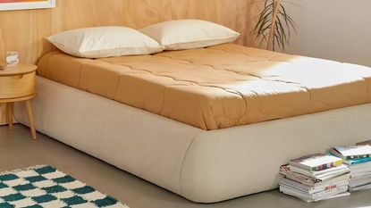 Platform bed frame with mattress and brown sheets from Urban Outfitters