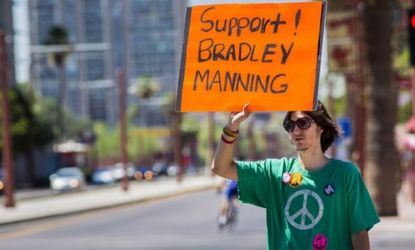 A supporter of U.S. Army PFC Bradley Manning pickets in Phoenix: A judge refused to drop charges against the alleged secret-spiller in the WikiLeaks case.