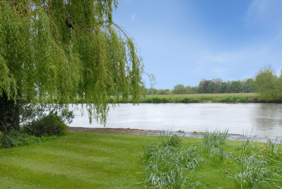 The house is on the Thames and has large fields around it.