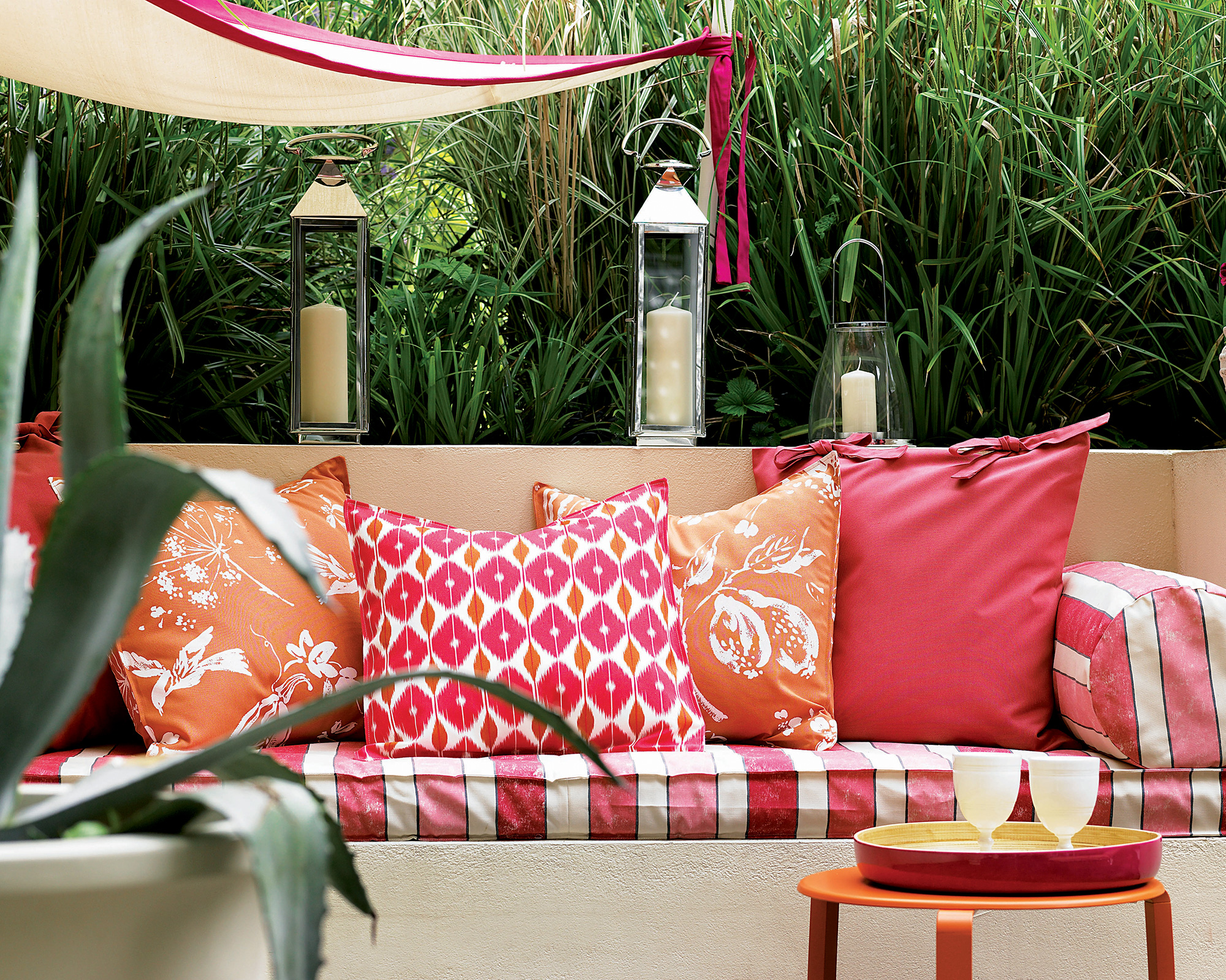 Garden decorating ideas showing a brightly colored bench seat surrounded by hurricane lanterns