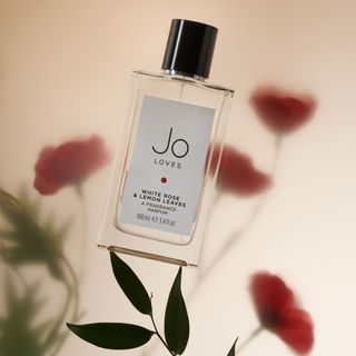 Jo Loves White Rose & Lemon Leaves Parfum floral perfume shot on some flower leaves