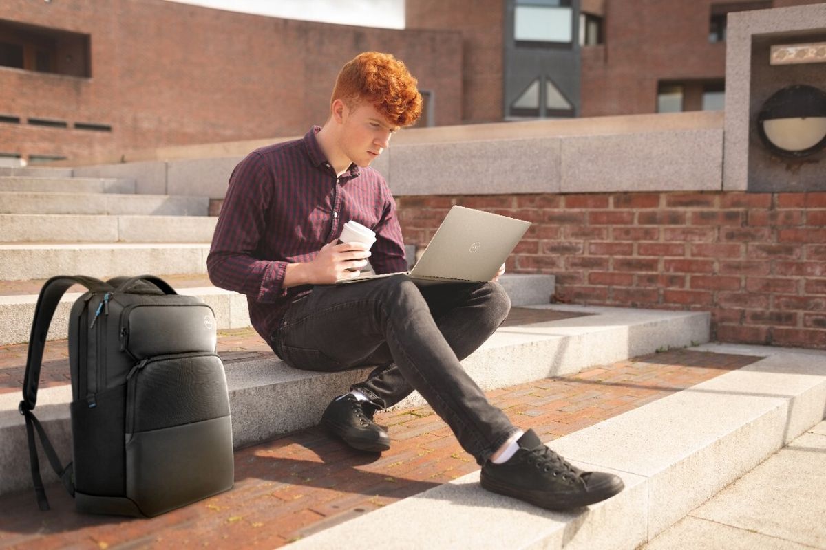 Student sitting on steps with coffee and Dell Laptop