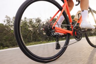 Shimano Cues groupset is shown close up while being ridden on a red bike