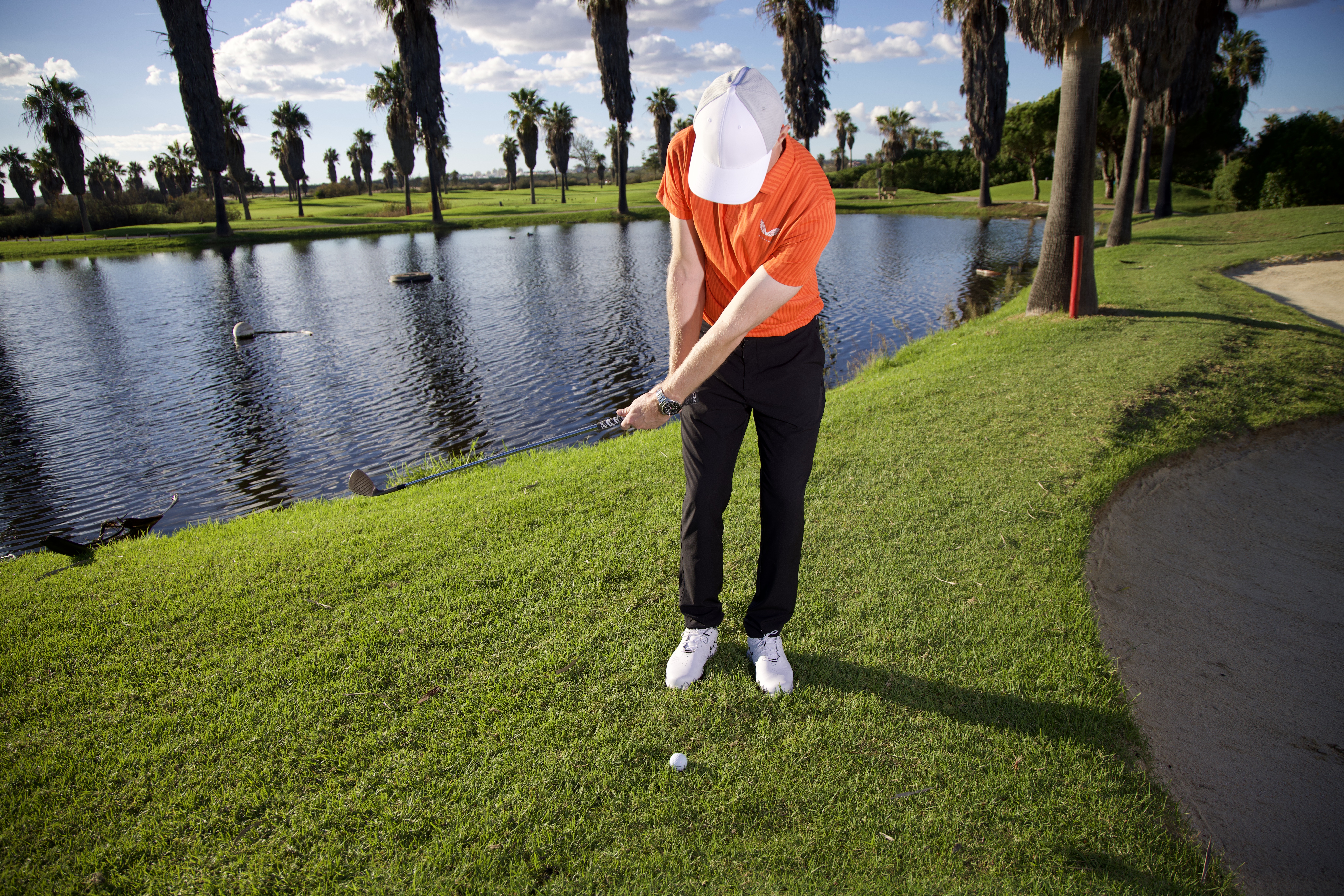 Ged Walters demonstrating a cross-handed chip shot over a bunker towards the green