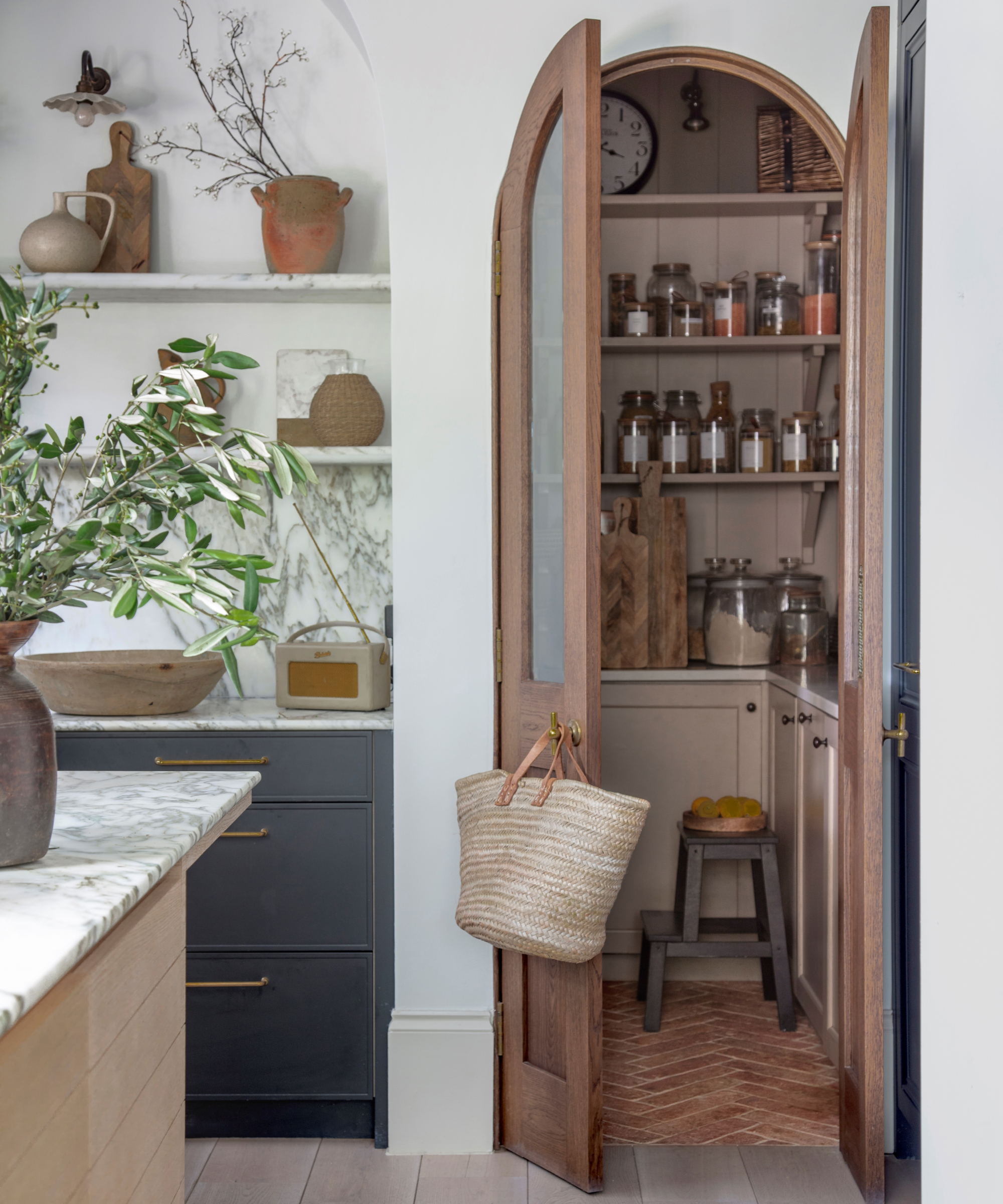 walk in pantry behind arched wooden and glass doors