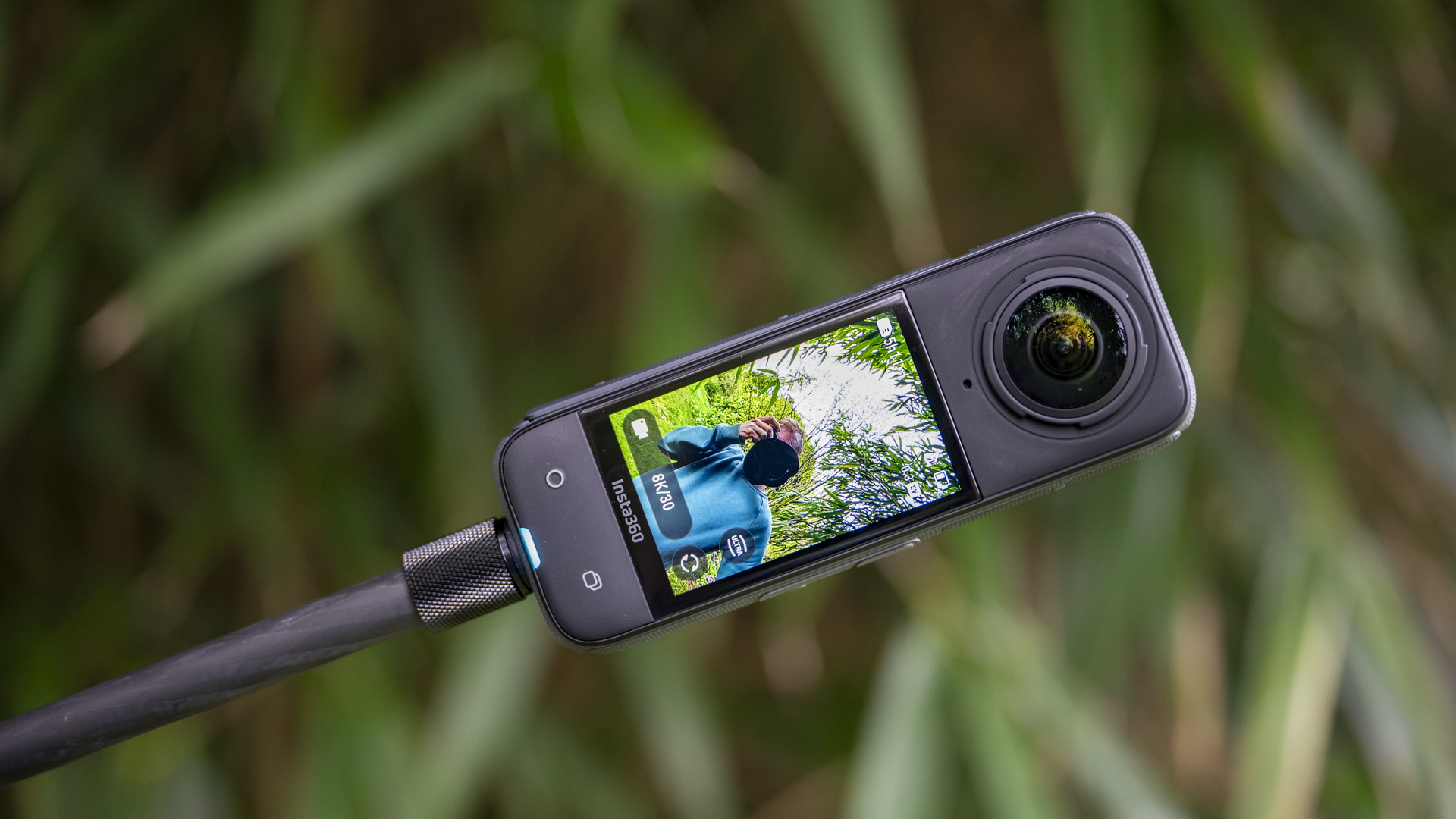 Insta360 X4 360 degree camera on a selfie stick recording video