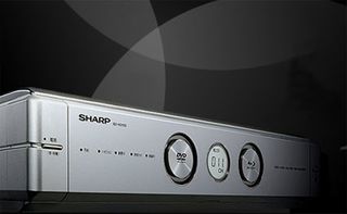 Sharp's BD-HD100 sports a fancy brushed steel front plate that hides its media slots, but - you may have guessed it - will only be available in Japan for now. What is special about this player is that it does not only play 25/50 GB discs, DVDs and CDs, bu