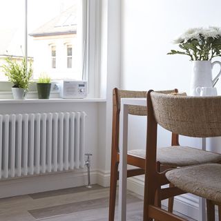 wooden chair with white wall white vase