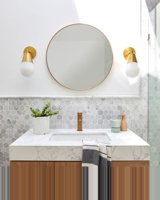 white and marble bathroom with brass fixtures by Interior Fox