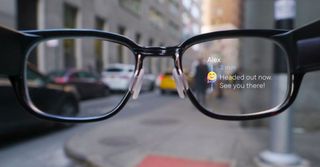 A pair of North Focals Smart Glasses showing a "Headd out now. See you there!" message on its AR lenses.