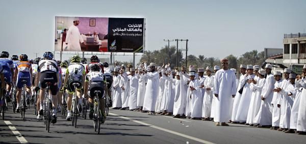 The peloton is cheered on by Omani spectators.