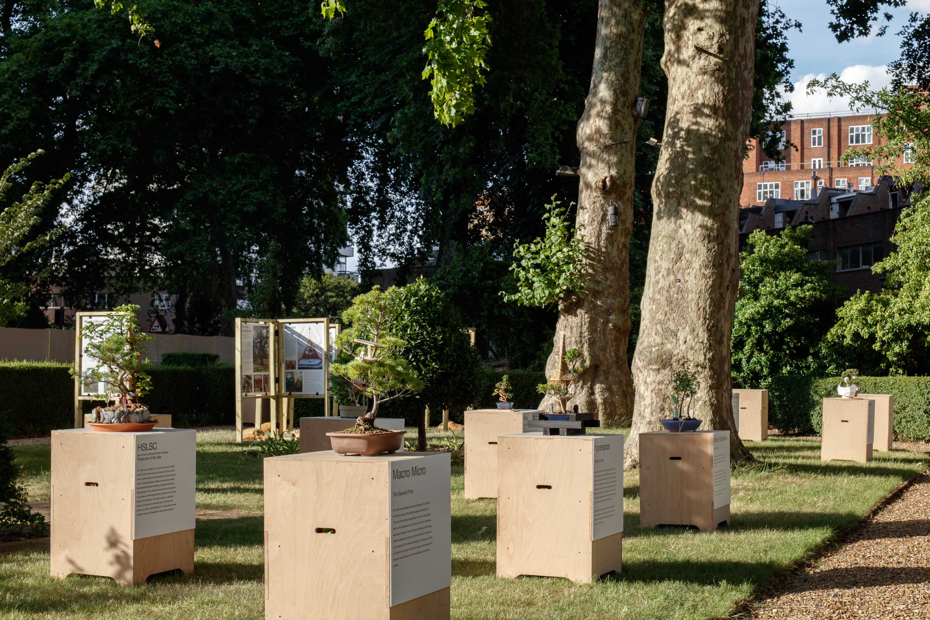 view of miniature houses in a park as part of an open air Bonsai treehouse exhibition in London