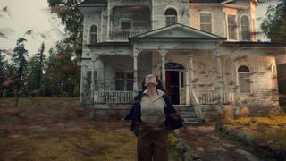 Nancy Bradley stands in front of a house as a violent wind hits her in The Murmuring on Netflix