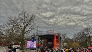 A cloudy sky above a stage and crowd.
