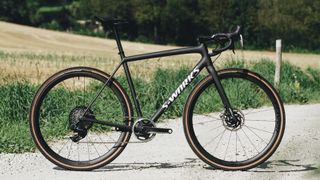 Best gravel race bikes: Specialized S-Works Crux 2022 in black on gravel road with fields in background