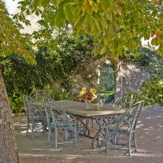 outdoor dining table with trees and flower vase