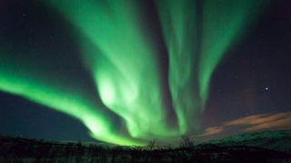 The brilliantly green northern lights on a dark night