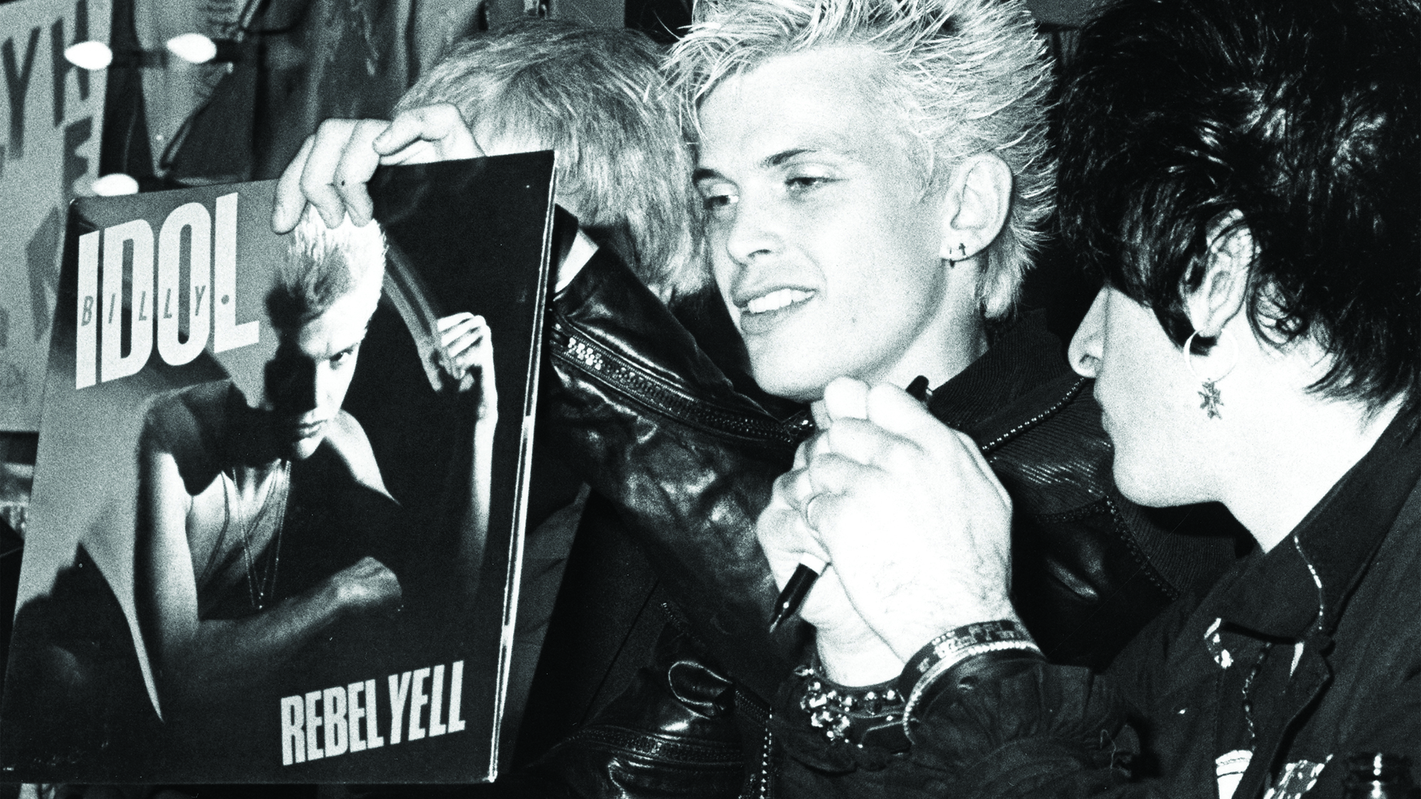 Billy Idol and Steve Stevens sign copies of Rebel Yell at a Hollywood promo, March 20, 1984.