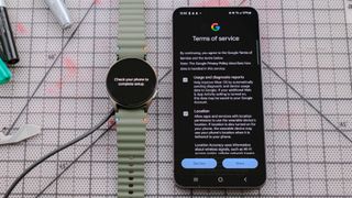 Samsung Galaxy Watch 7 next to a Samsung Galaxy S24 smartphone showing the Google sign in page