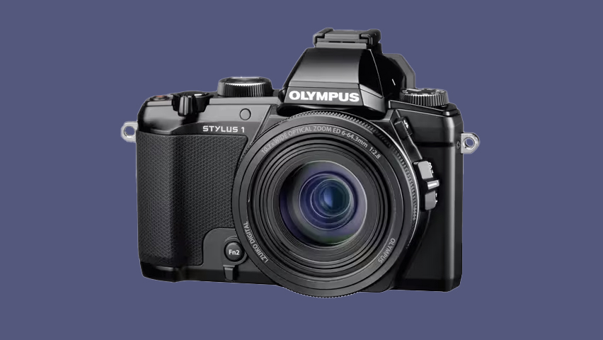 The Olympus Stylus 1 compact camera on a blue background