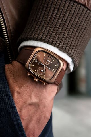 brown watch on man's wrist, with leather strap