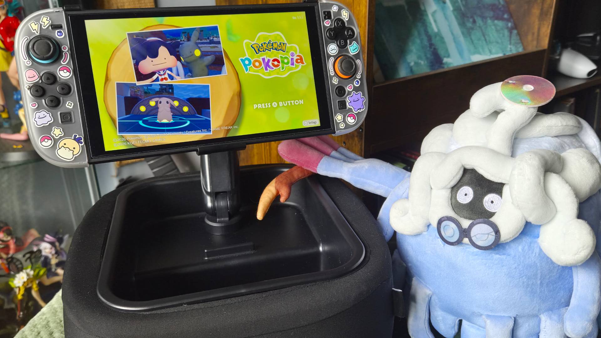 Photo of a plush of Professor Tangrowth from Pokemon Pokopia sitting next to the Lululook Switch 2 Gaming Pillow.