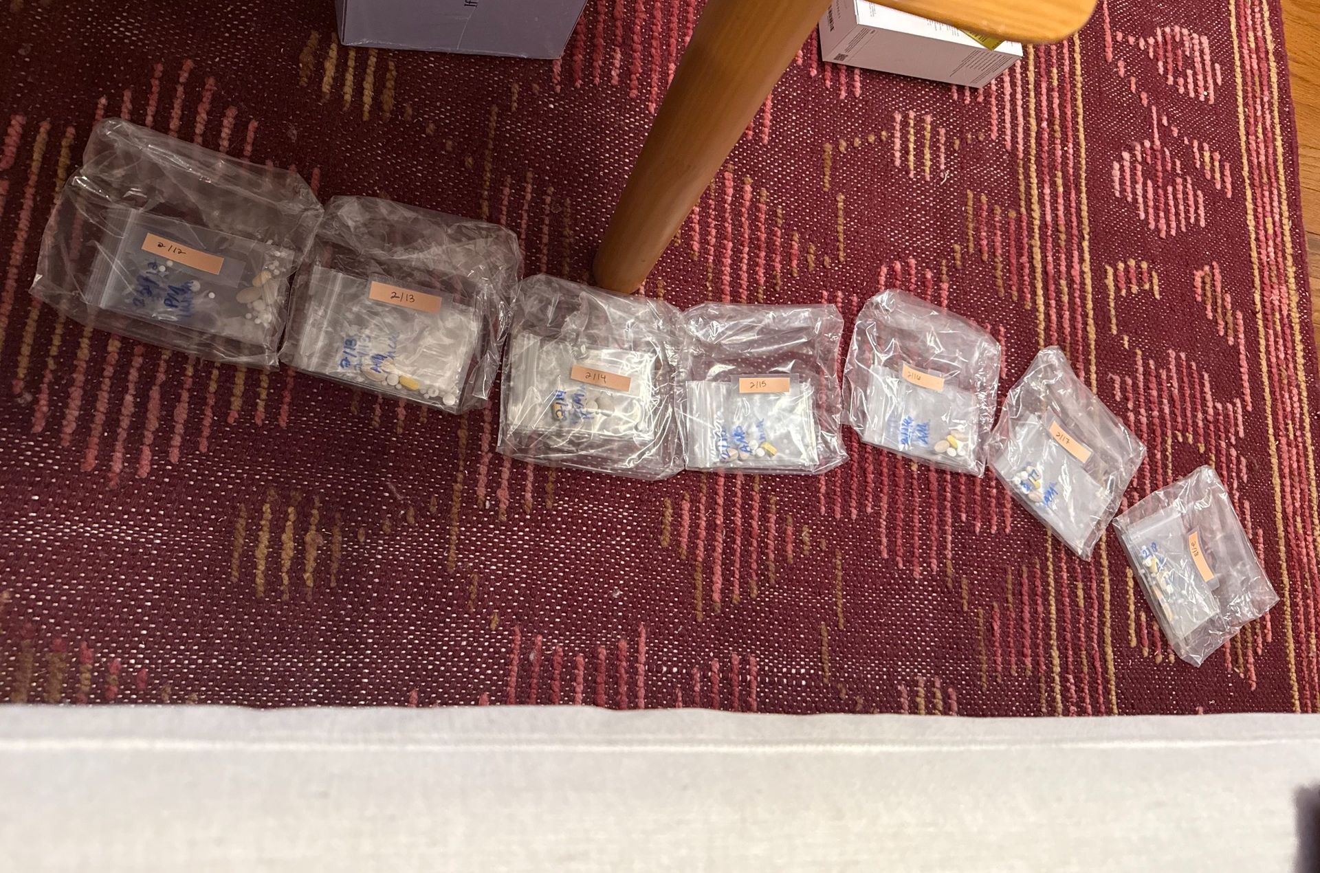 organized vitamins in plastic baggies on a red rug