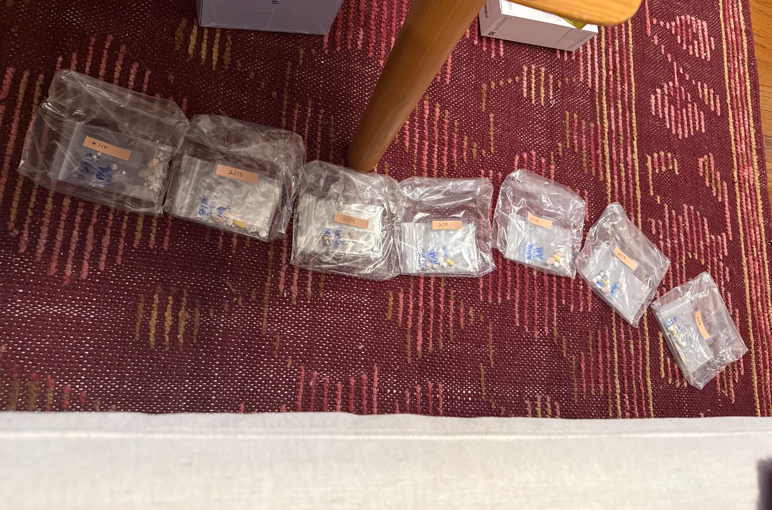 organized vitamins in plastic baggies on a red rug
