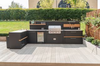 how to design an outdoor kitchen: modern black outdoor kitchen with units and built in BBQ
